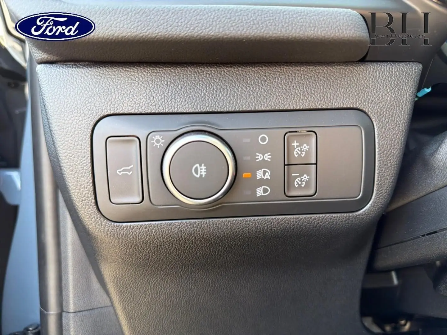 Gros plan sur la commande d’éclairage noire à gauche du tableau de bord du Ford Kuga bleu 2026.