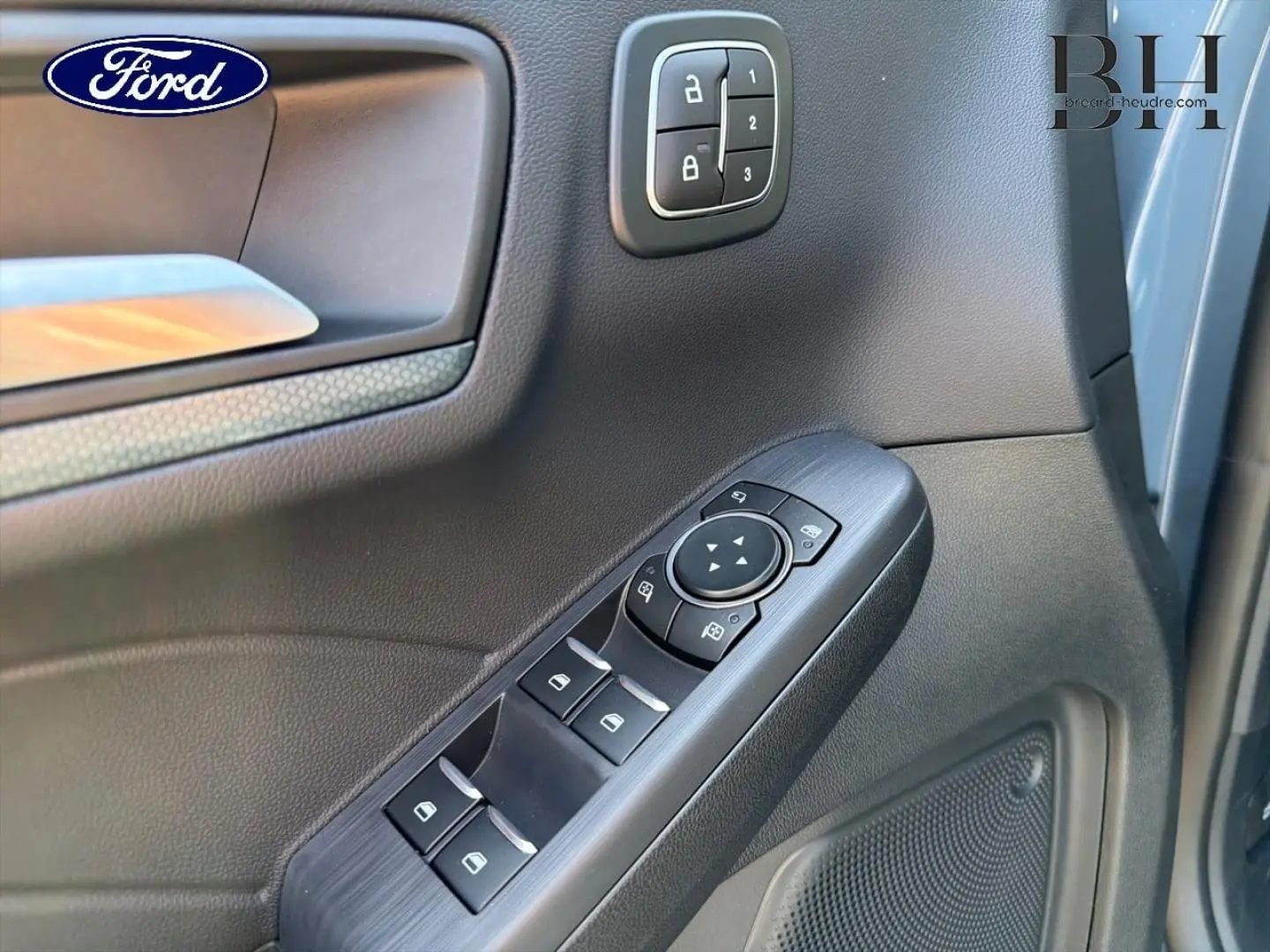 Détail de la porte avant gauche du Ford Kuga 2026 avec commandes de vitres et verrouillage en plastique noir.