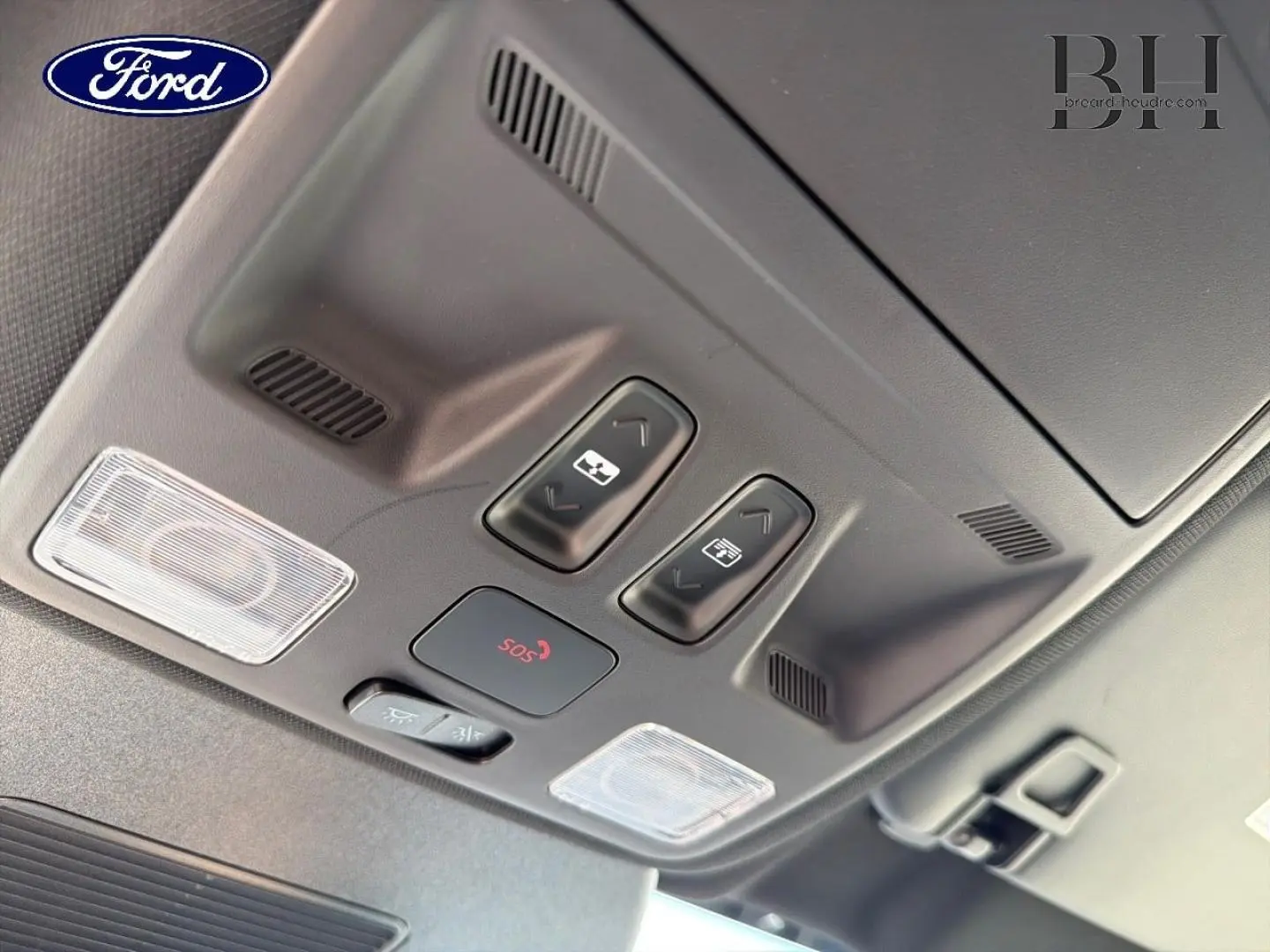 Vue en plongée sur les commandes du toit ouvrant panoramique et l’éclairage intérieur du Ford Kuga bleu 2026.