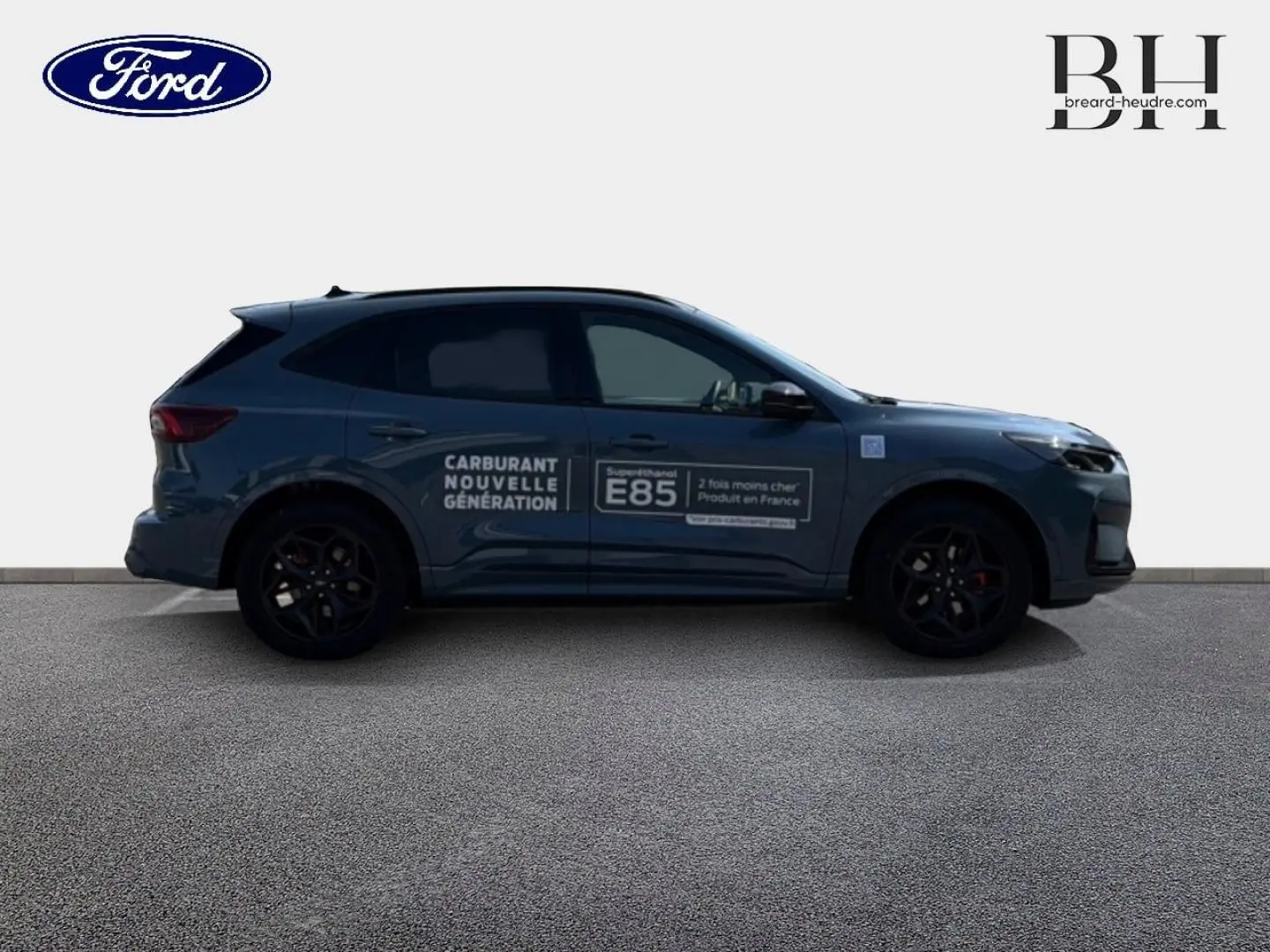 Ford Kuga bleu Vapor métallisé vu de profil droit avec marquage publicitaire E85 sur la porte.