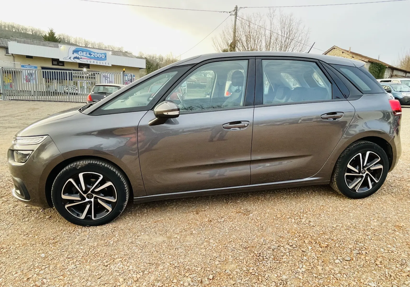 Profil côté gauche d'une Citroën C4 Picasso gris métal de 2018, avec jantes alliage et carrosserie lisse.