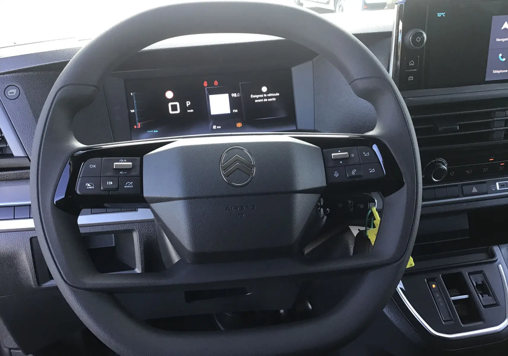 Vue rapprochée du volant noir du Citroën Jumpy XL gris titane, avec tableau de bord numérique et écran central visible.