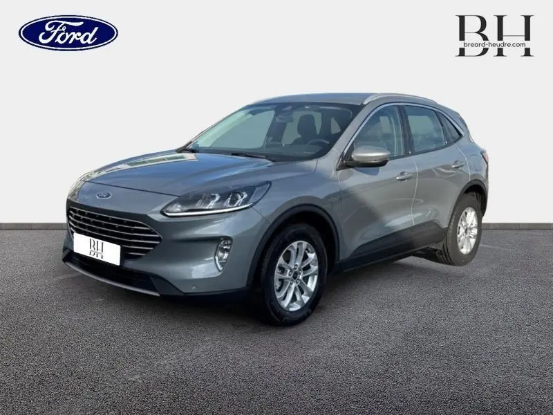 Ford Kuga 2023 gris Solar métallisé en vue 3/4 avant, mettant en valeur sa calandre large et ses jantes alu.