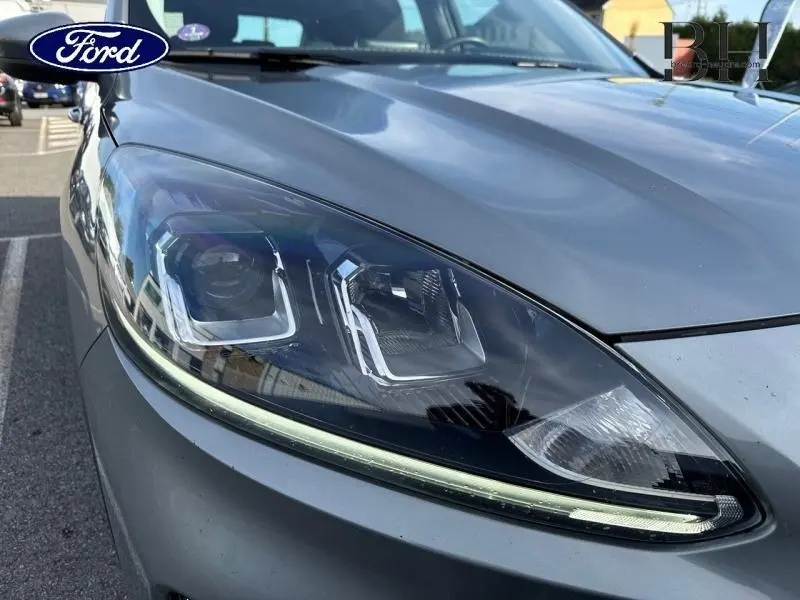 Gros plan sur le phare avant gauche du Ford Kuga 2023 gris Solar métallisé avec éclairage LED distinctif.