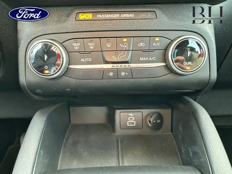 Gros plan sur la console centrale du Ford Kuga 2023 gris, montrant la climatisation bi-zone et prises USB et 12V.