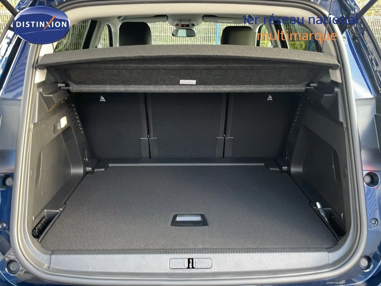 Coffre ouvert vu de l'arrière d'un Citroën C5 Aircross bleu Eclipse Metal avec cache-bagages en place.