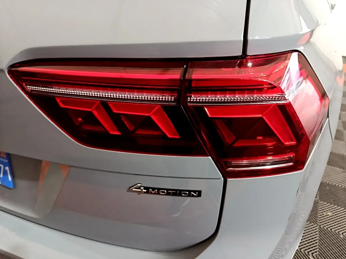 Feu arrière droit rouge et badge 4Motion sur le coffre gris foncé d'un Volkswagen Tiguan 2021.