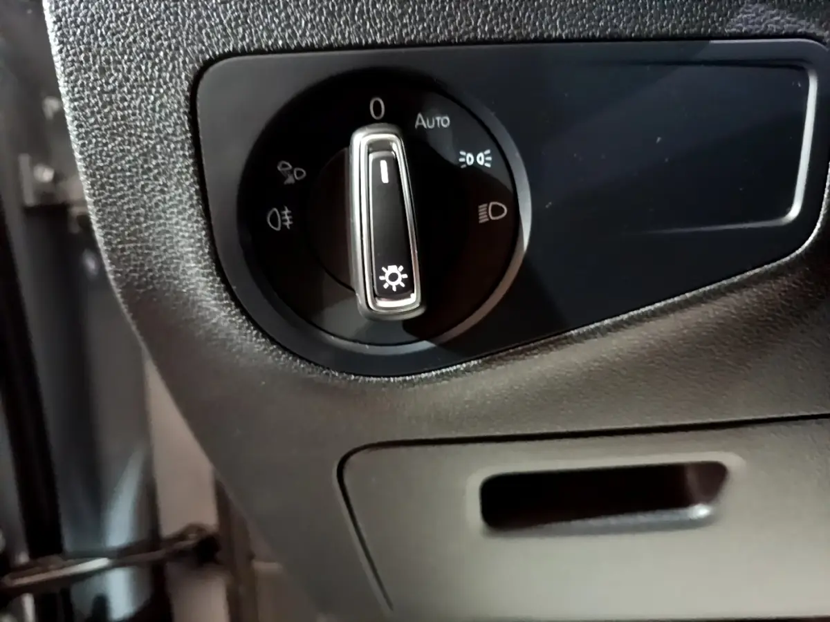 Gros plan sur la commande des phares dans l'habitacle noir du Volkswagen Tiguan gris foncé 2021.