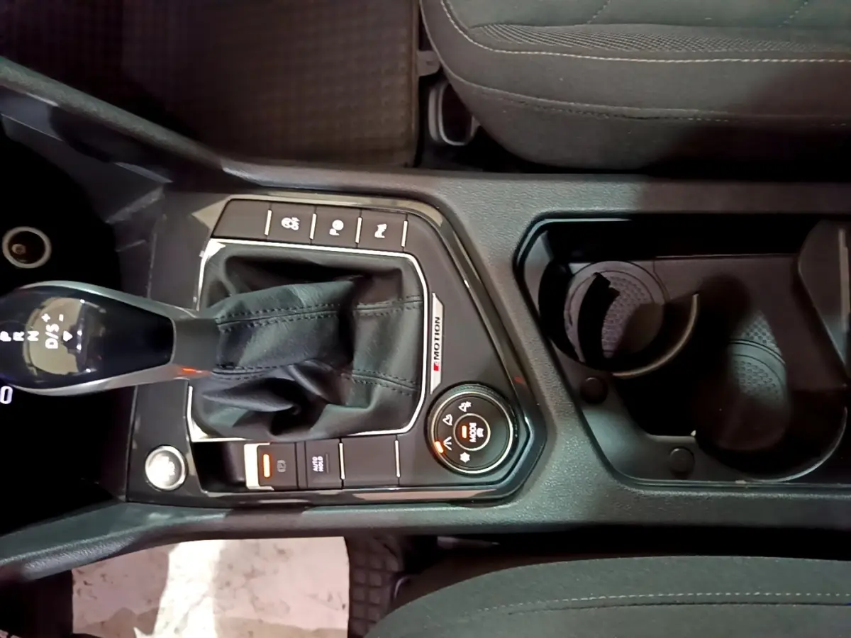 Vue plongeante sur la console centrale du Volkswagen Tiguan gris foncé, avec levier de vitesses DSG7 et commandes 4Motion.