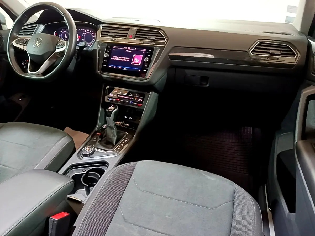 Intérieur du Volkswagen Tiguan 2.0 TDI 2021, vue côté conducteur sur tableau de bord et console centrale noire.