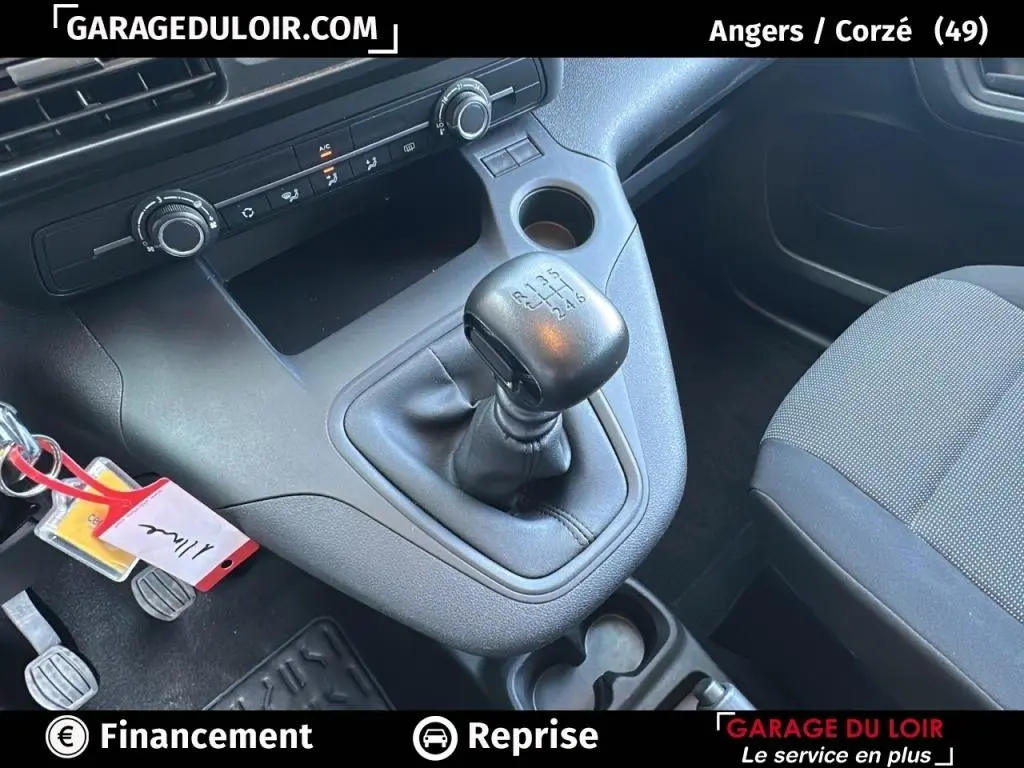 Intérieur du Peugeot Rifter 2024 bleu, vue rapprochée sur la boîte manuelle et la console centrale noire.