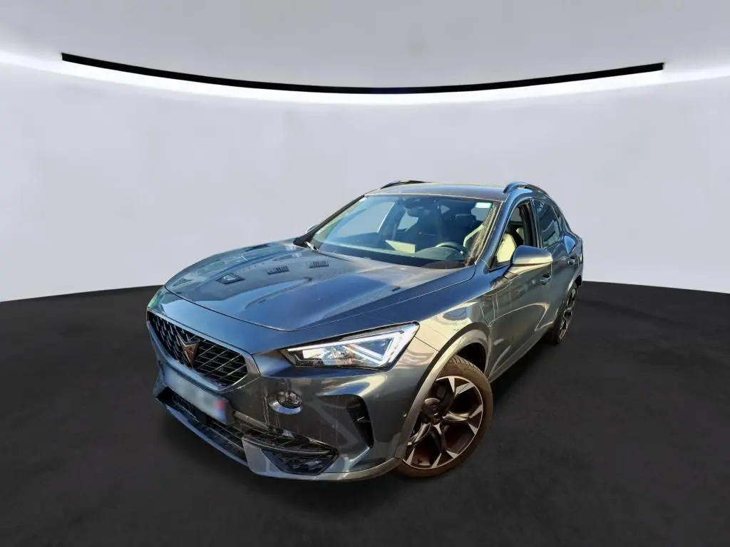 Vue 3/4 avant d’un CUPRA Formentor gris foncé avec jantes noires et calandre distinctive, sur fond neutre.