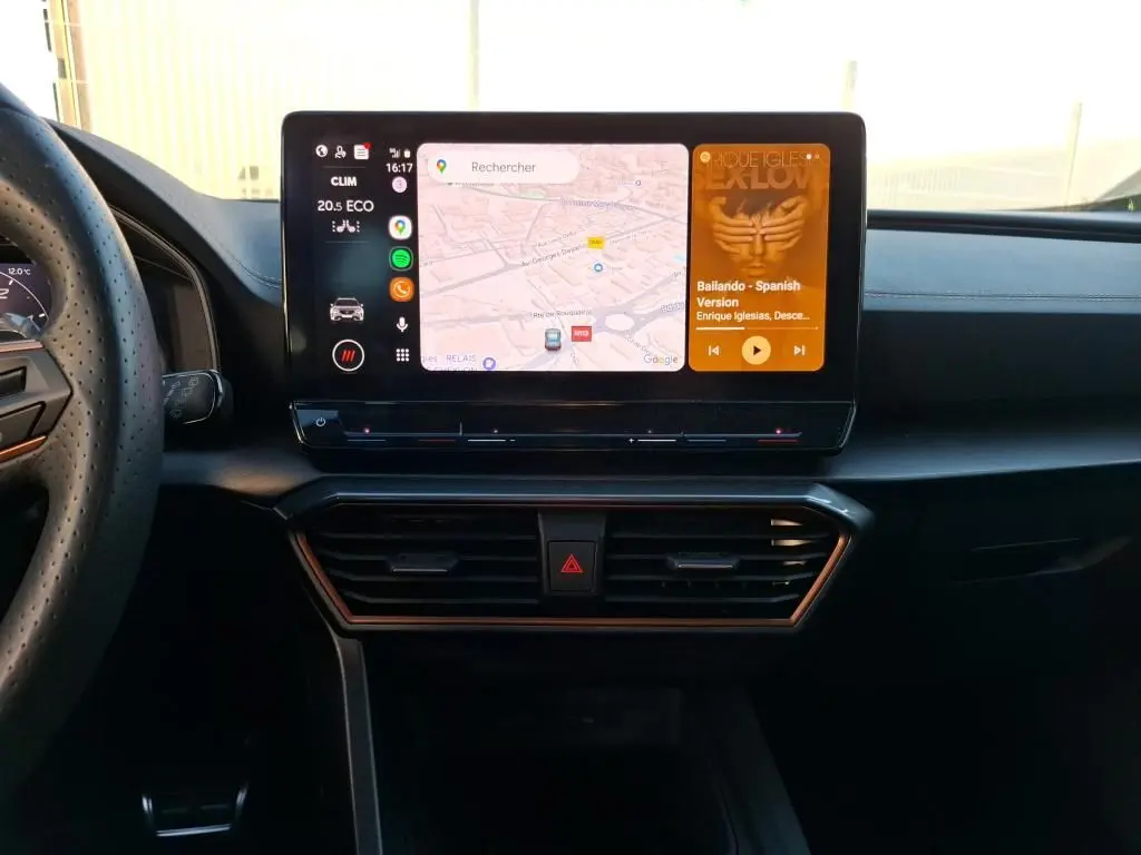 Vue intérieure du tableau de bord de la CUPRA Formentor 1.4 e-HYBRID 2023 avec écran tactile affichant navigation et musique.