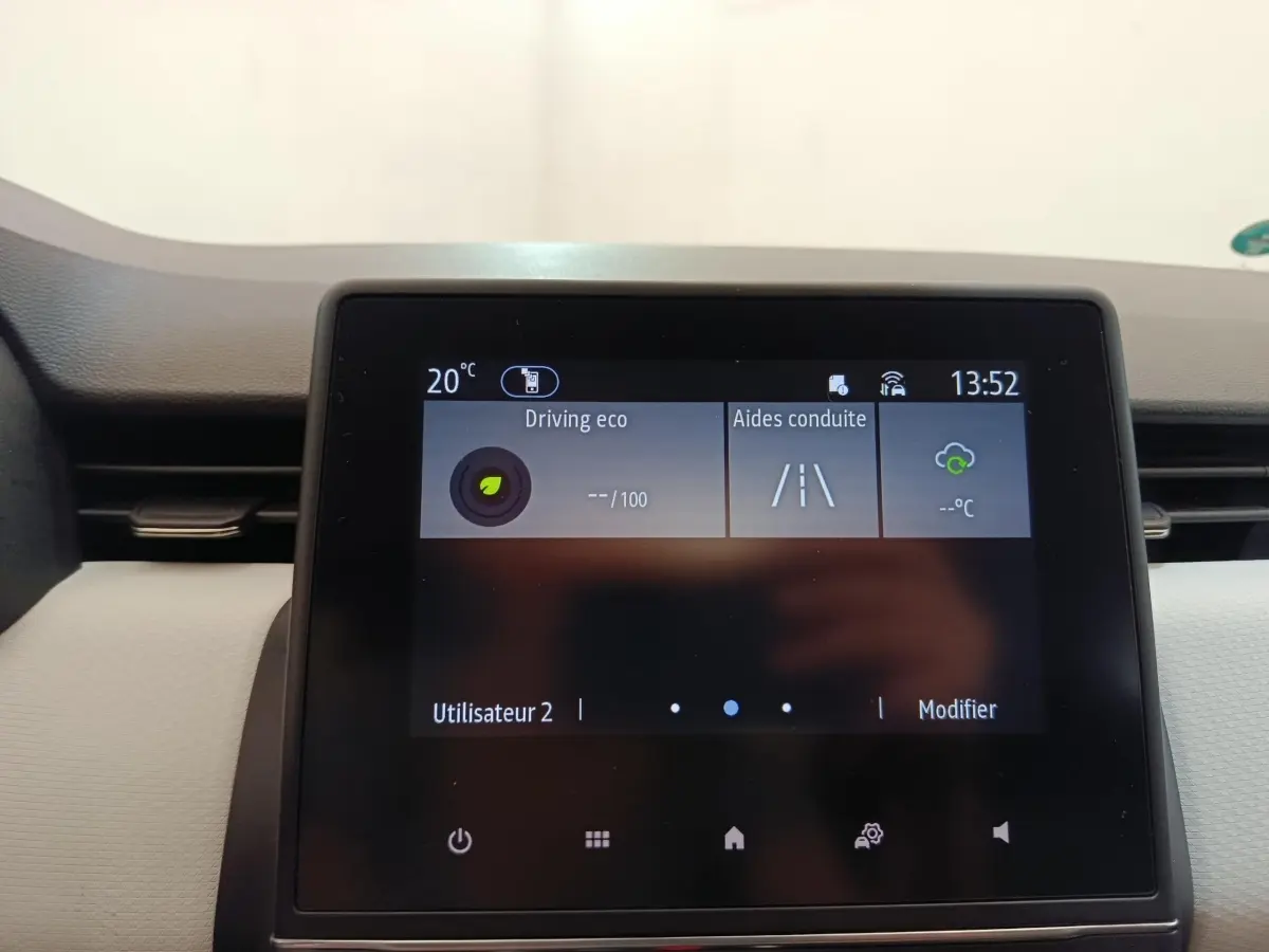 Écran tactile central de la Renault Clio blanc, affichant les aides à la conduite et la température intérieure.