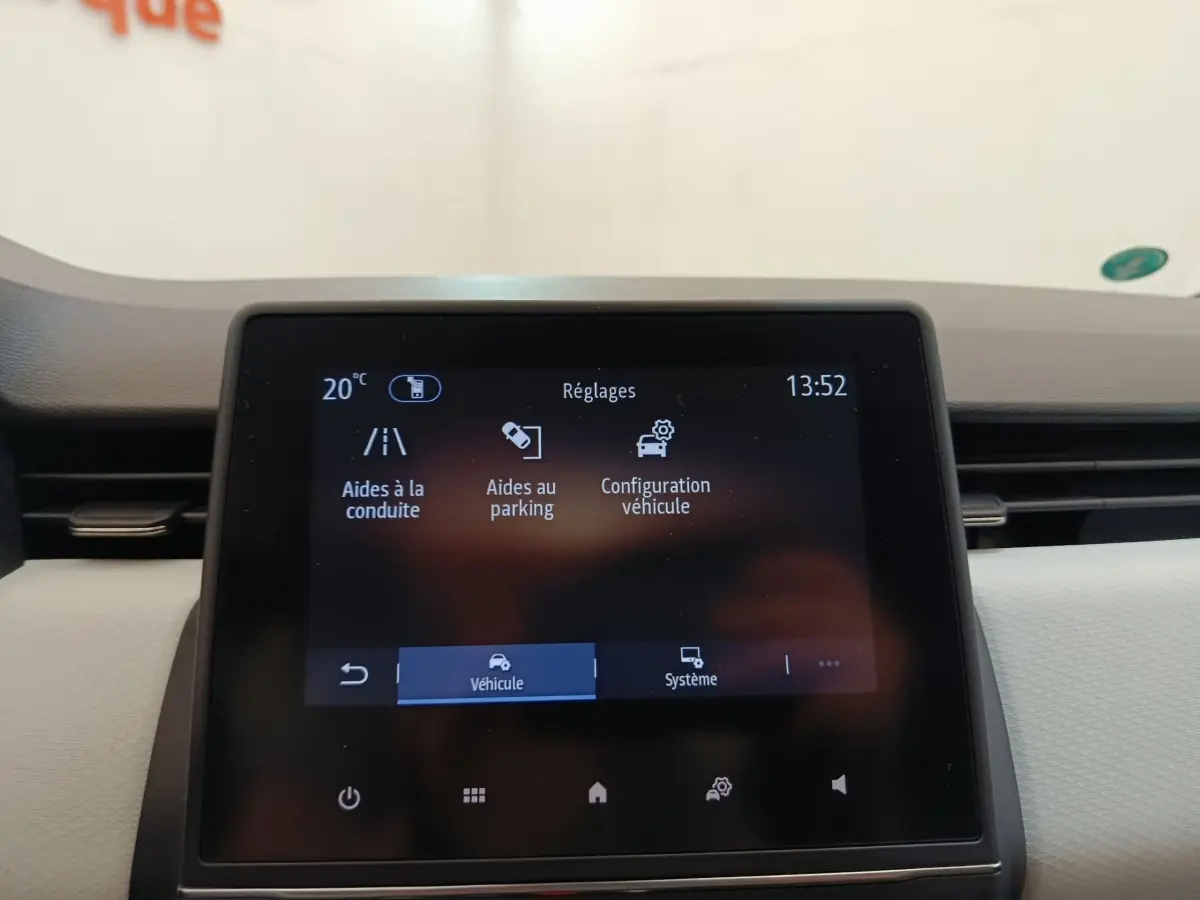 Écran tactile central de la Renault Clio blanc 2023 affichant les réglages d’aides à la conduite et parking.