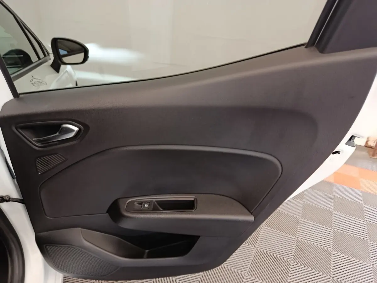 Vue intérieure de la porte arrière droite noire de la Renault Clio blanche Evolution TCe 100 GPL 2023.