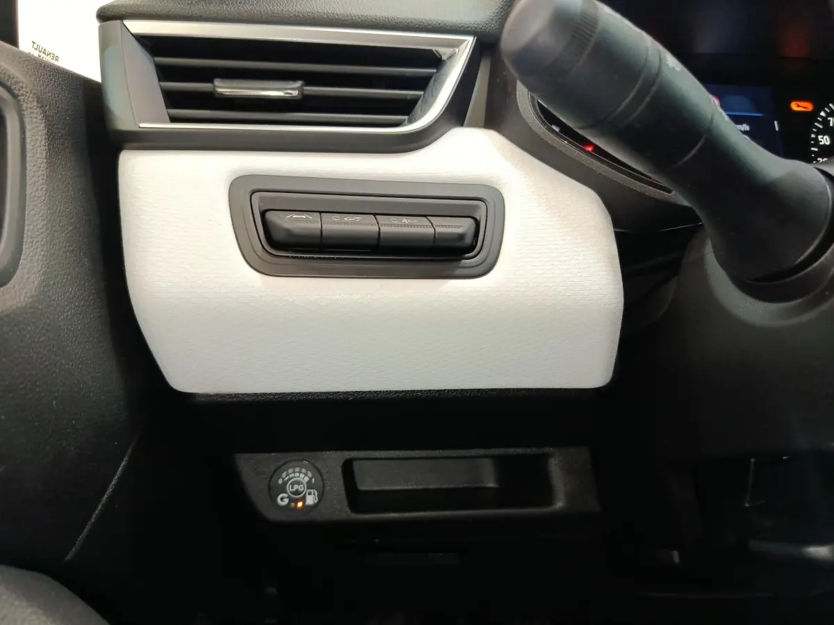 Détail intérieur côté conducteur de la Renault Clio blanche 2023 montrant les commandes et le bouton GPL.