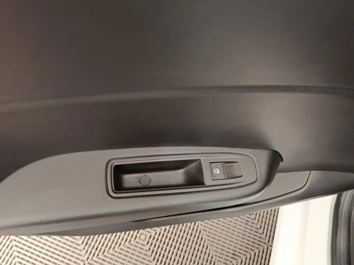 Détail de la poignée intérieure noire de porte côté conducteur d'une Renault Clio blanche 2023.