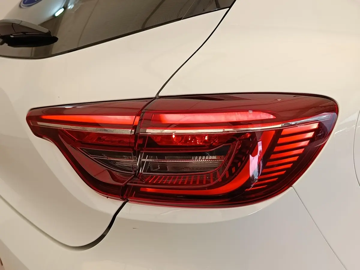 Gros plan sur le feu arrière droit rouge de la Renault Clio blanche Evolution TCe 100 GPL de 2023.