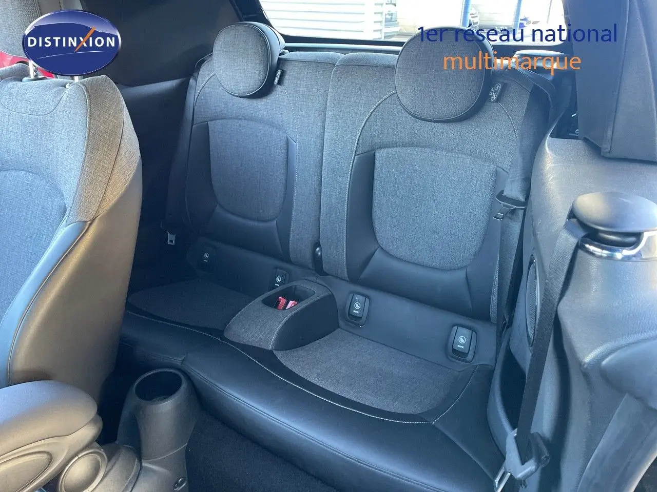 Vue intérieure arrière montrant les sièges arrière gris tissu et cuir d'une MINI Cabriolet F57 noire 2023.