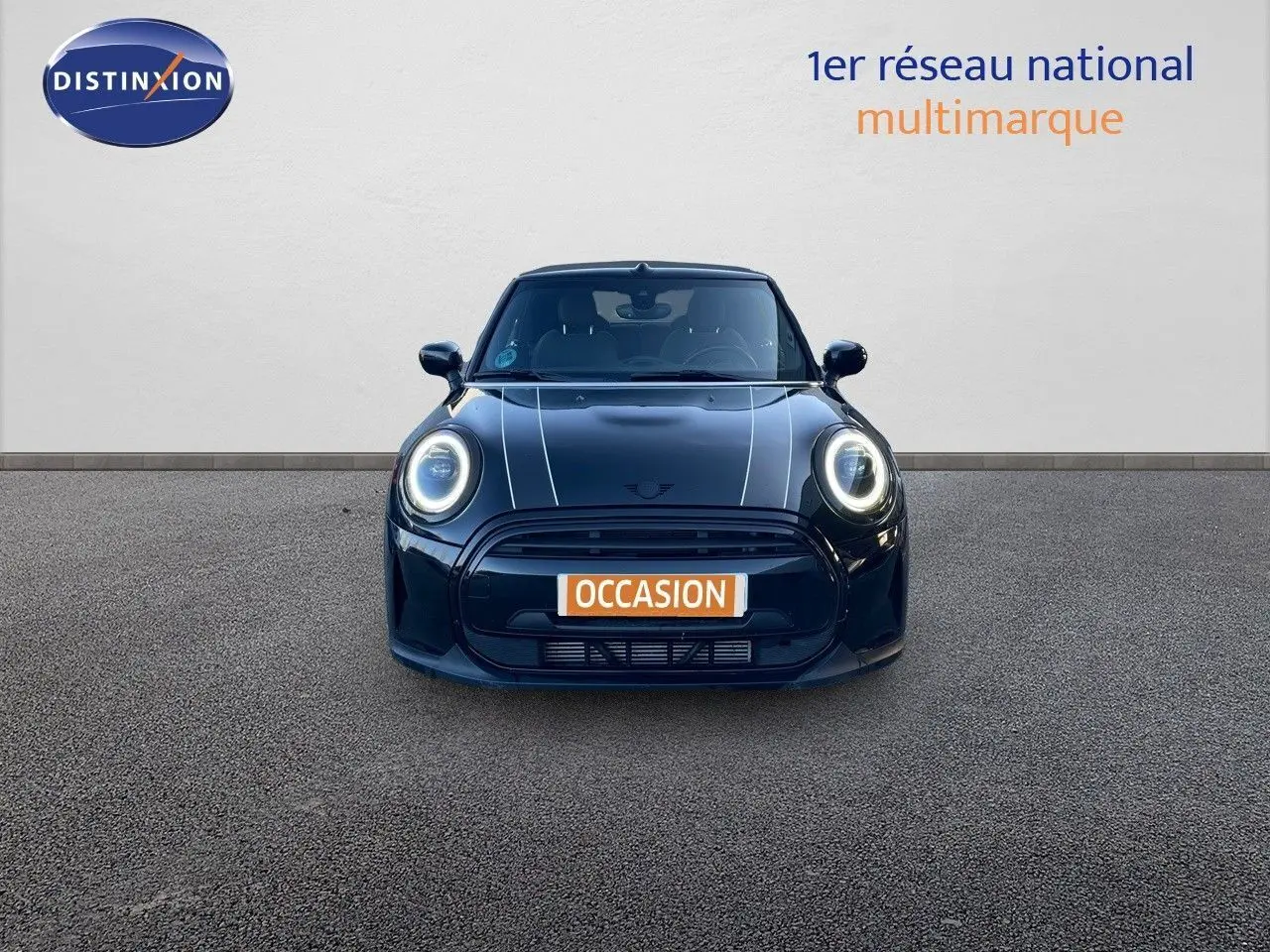 Vue frontale d'une MINI Cabriolet F57 noire Midnight Metal avec phares LED allumés et plaques "OCCASION" visible.
