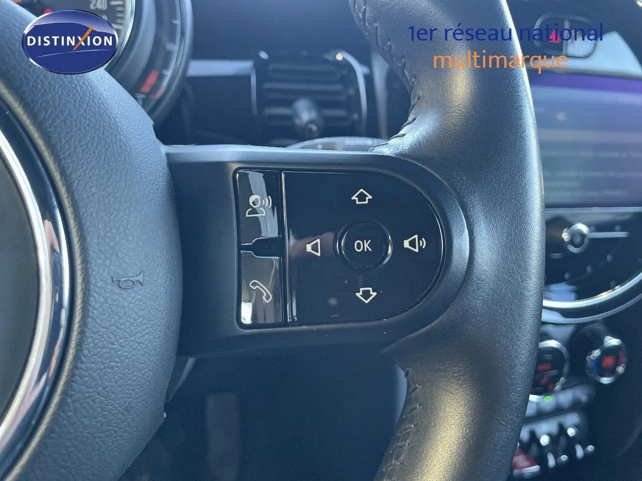 Gros plan sur les commandes au volant en cuir noir du MINI Cabriolet F57 2023, avec tableau de bord en arrière-plan.