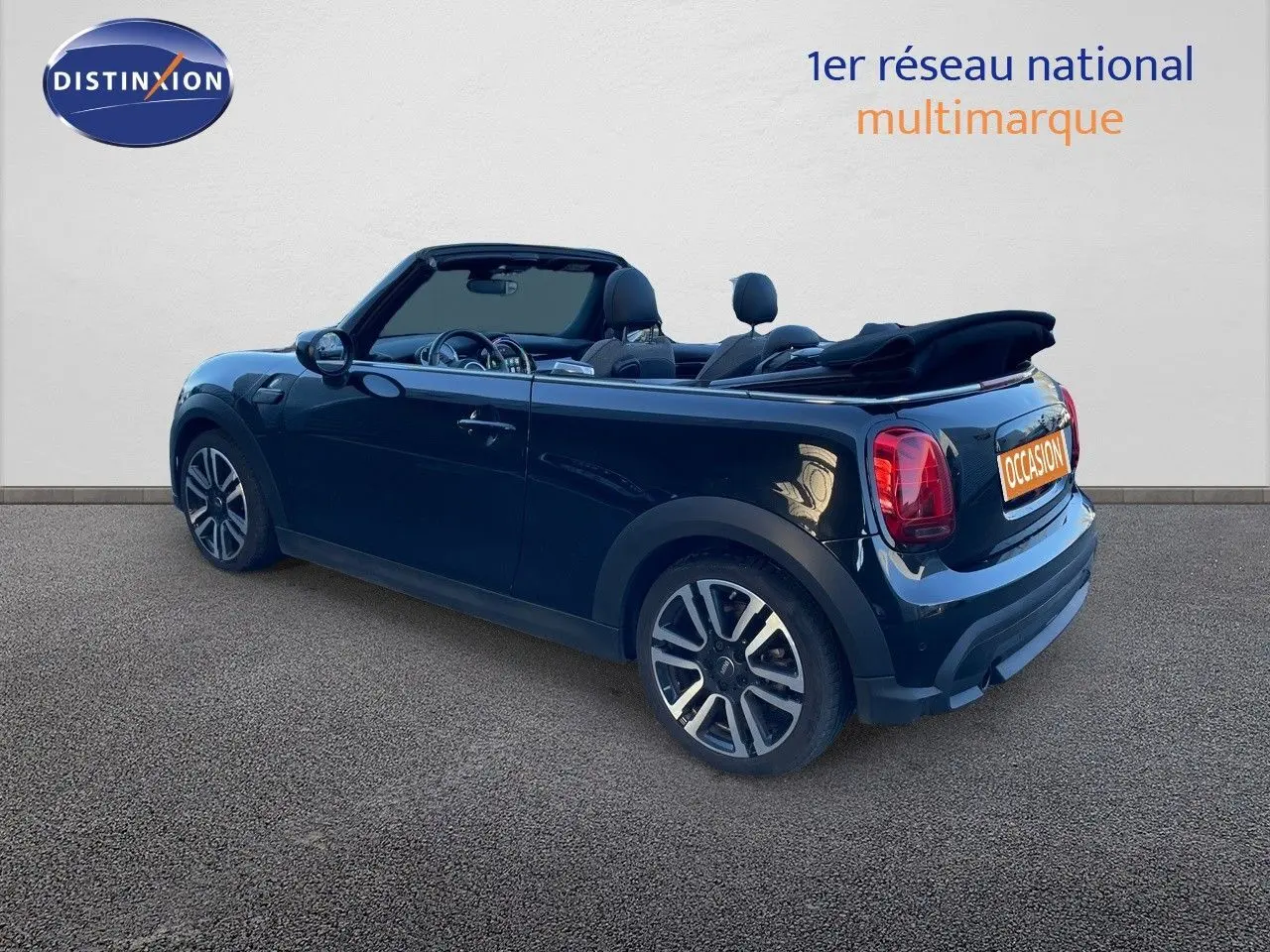 MINI Cabriolet noir Midnight Metal vue 3/4 arrière côté droit, capote ouverte et jantes bi-ton visibles.