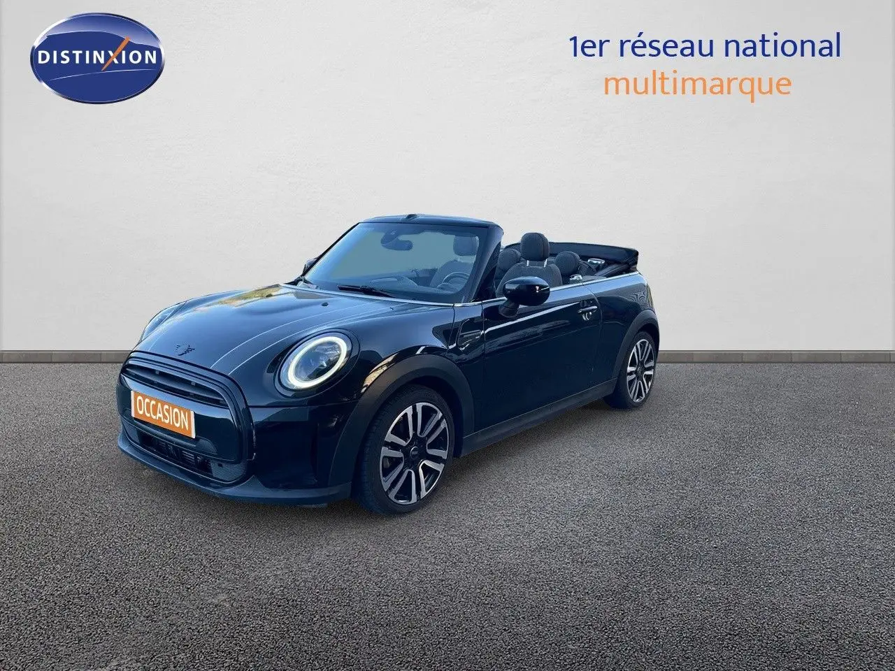 MINI Cabriolet noir Midnight Metal vue 3/4 avant avec capote ouverte et jantes bi-ton visibles.