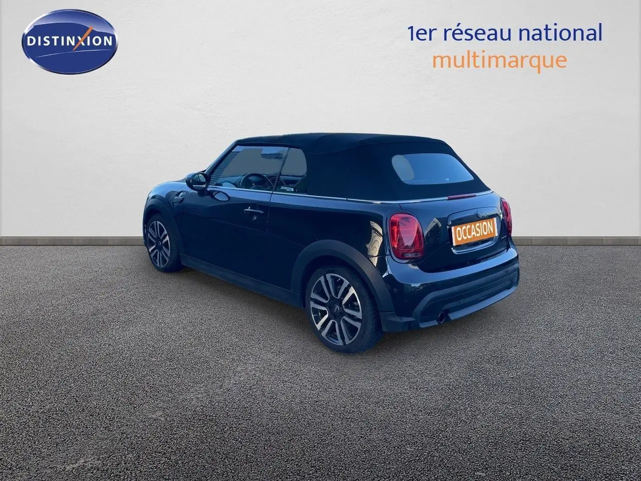 Vue 3/4 arrière droite d'une MINI Cabriolet F57 noire Midnight Metal avec capote noire et jantes bi-ton.