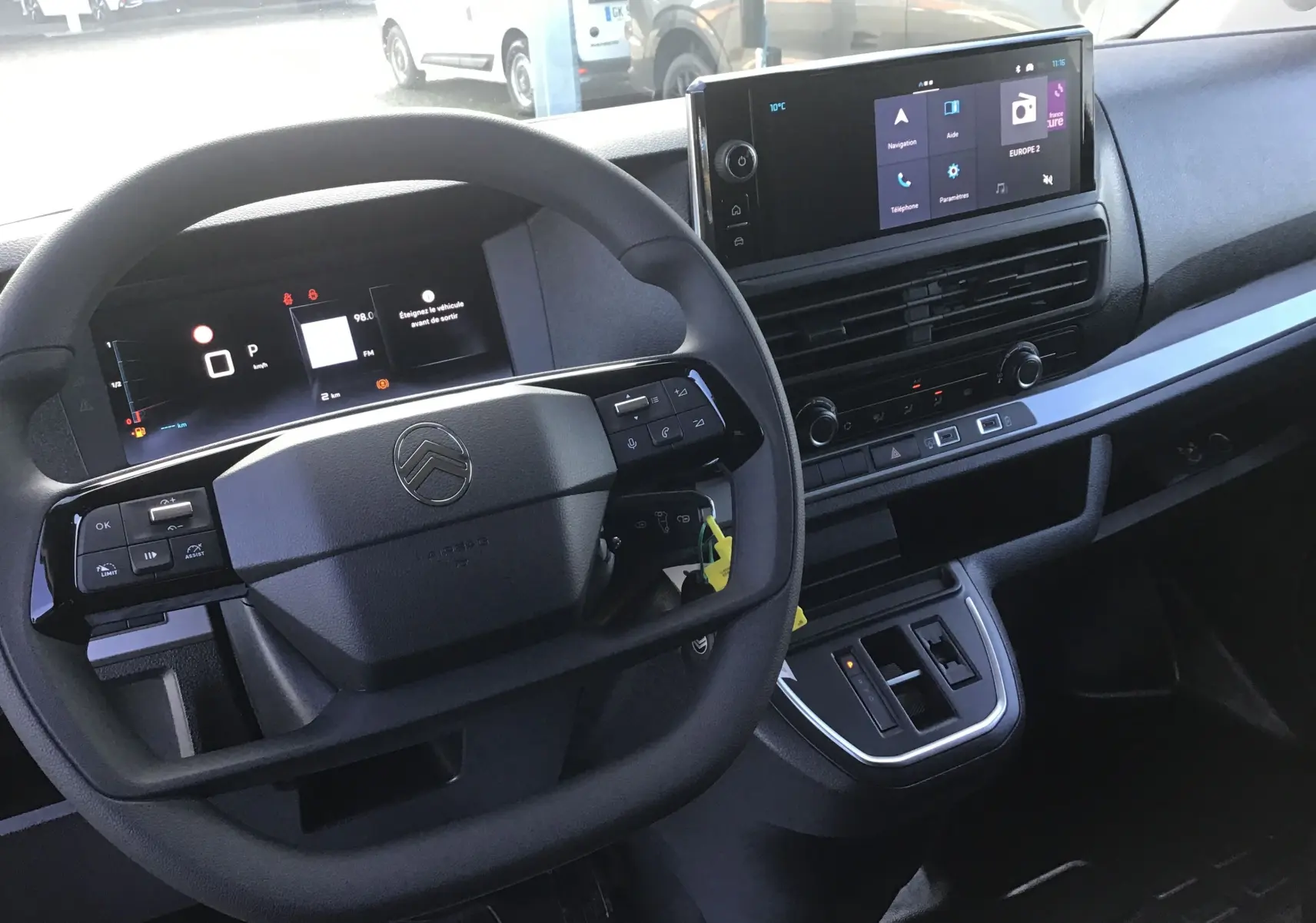 Vue intérieure centrée sur le volant et tableau de bord numérique du Citroën Jumpy cabine approfondie gris titane.