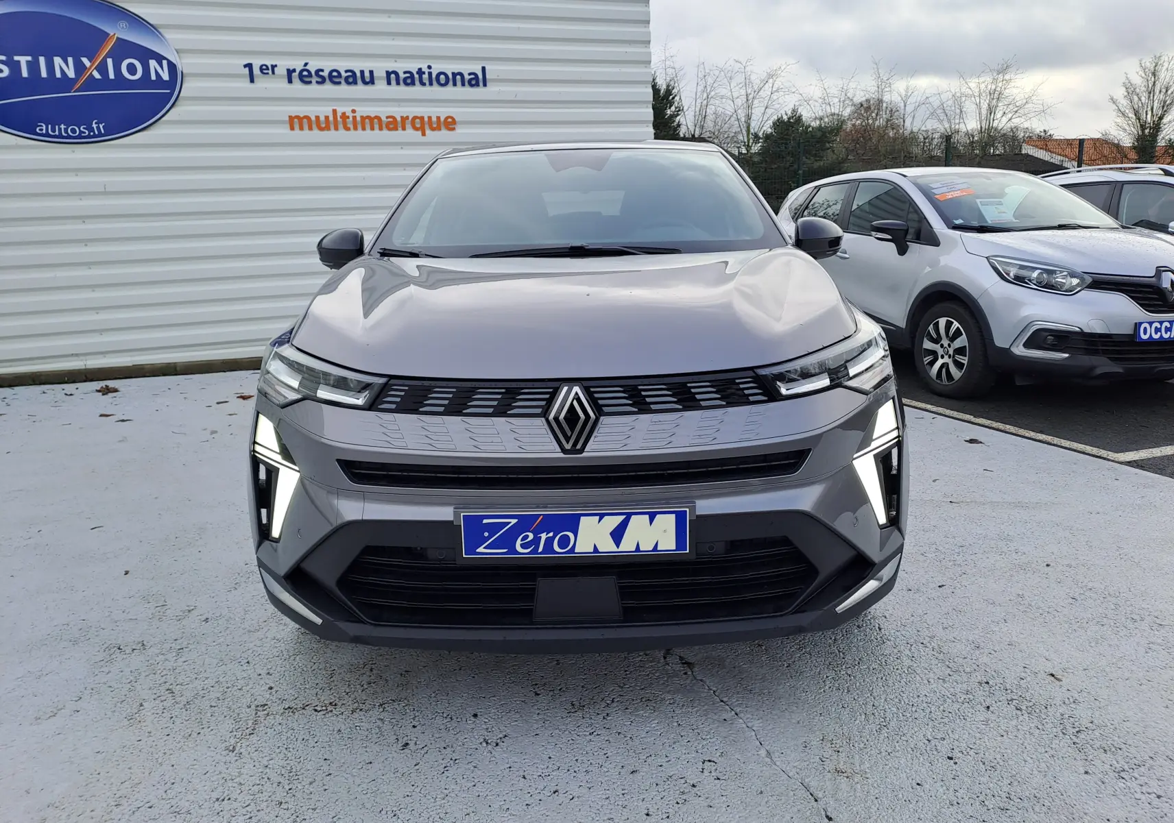 Vue 3/4 avant droite d’un Renault Symbioz gris Cassiopée avec feux LED en forme de C et jantes bi-ton.