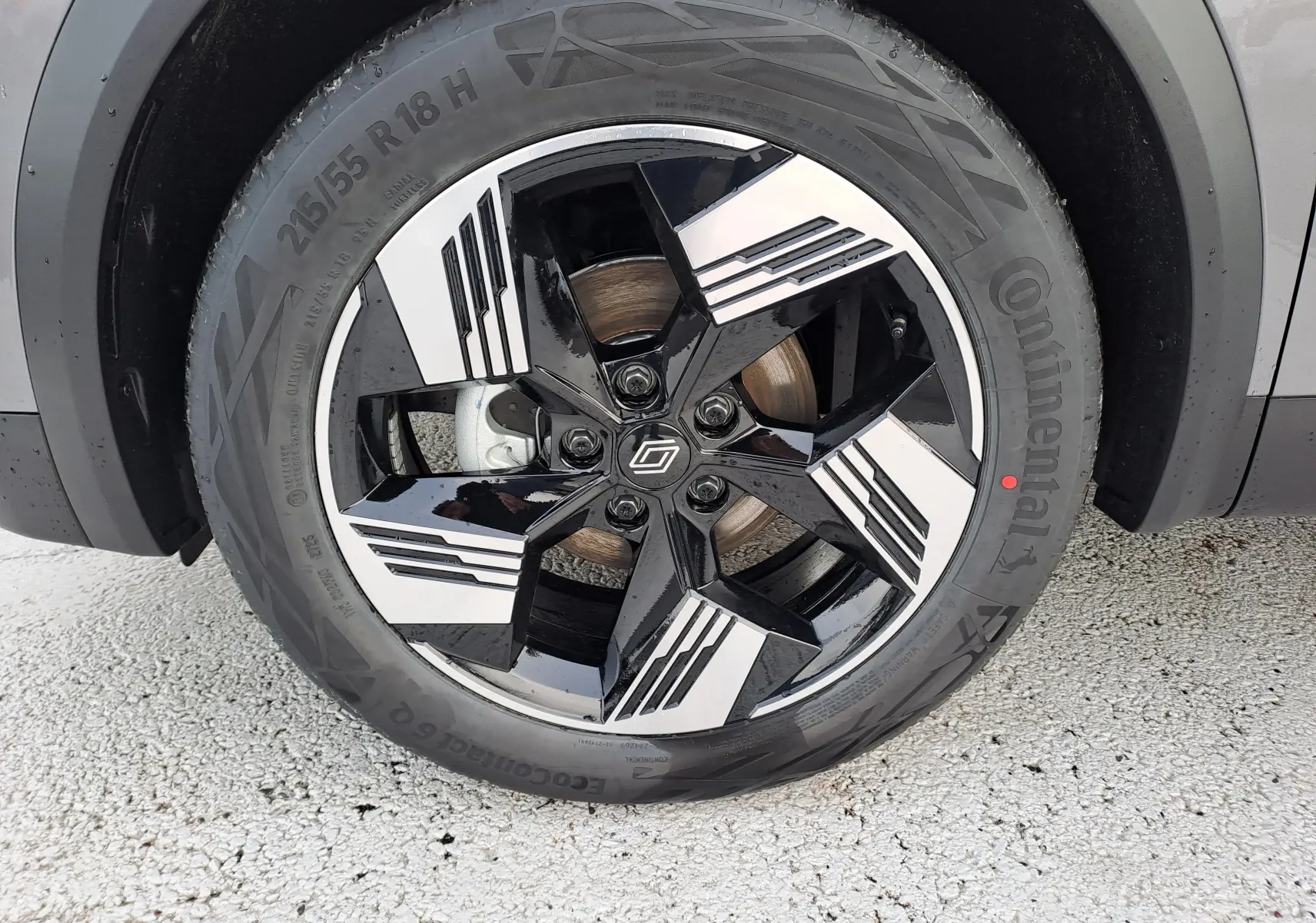 Gros plan sur la roue avant droite du Renault Symbioz gris Cassiopée avec jante noire et argentée au design géométrique.