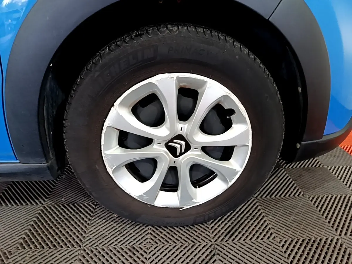 Gros plan sur la roue avant gauche de la Citroën C3 bleu avec jante alliage et logo Citroën central.