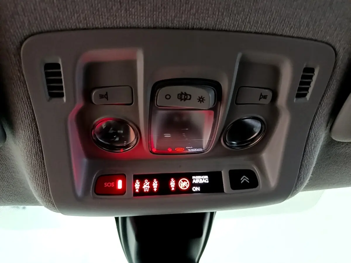 Panneau de commandes plafonnier intérieur avec voyants rouges et boutons d’éclairage dans une Citroën C3 bleu 2017.