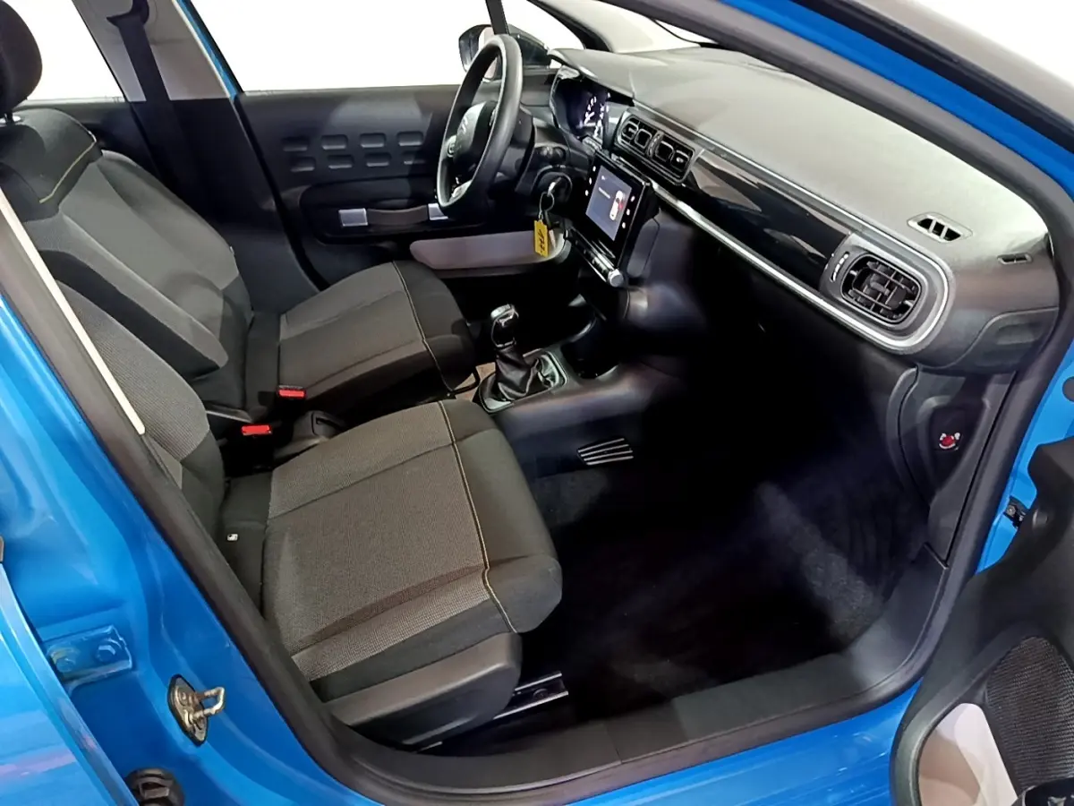 Vue intérieure côté conducteur d'une Citroën C3 bleu 2017 avec tableau de bord noir et écran tactile central.