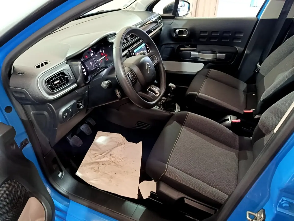 Intérieur avant droit d'une Citroën C3 bleu 2017, montrant sièges tissu et tableau de bord avec écran tactile.