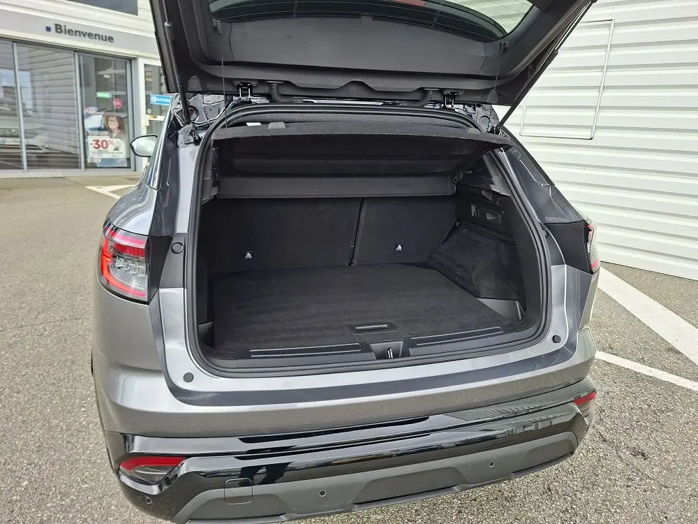 Coffre ouvert vu de l’arrière d’un Renault Austral gris schiste, montrant l’espace de chargement vide et le hayon relevé.