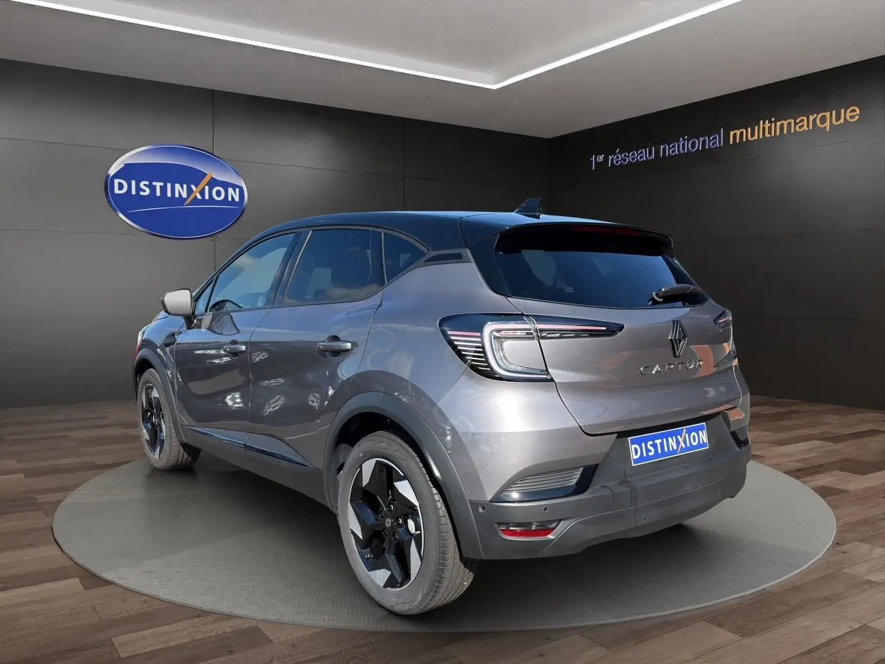 Vue 3/4 arrière droite du Renault Captur TCE 90 Techno 2024 gris Cassiopée avec toit noir et jantes bicolores.