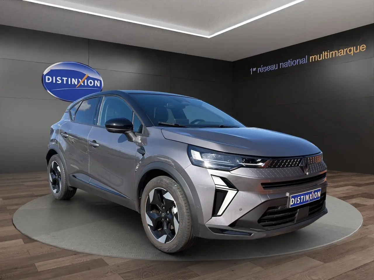 Renault Captur TCE 90 Techno gris Cassiopée avec toit noir, vue 3/4 avant mettant en valeur ses optiques LED et jantes noires.