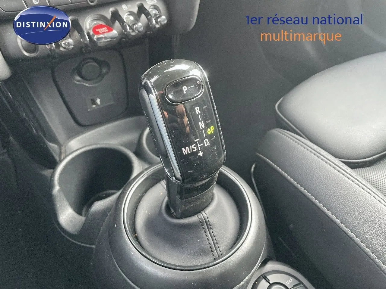 Le levier de vitesses automatique noir de la MINI 1.5 136CH STEPTRONIC, avec console et siège en cuir noir visible.