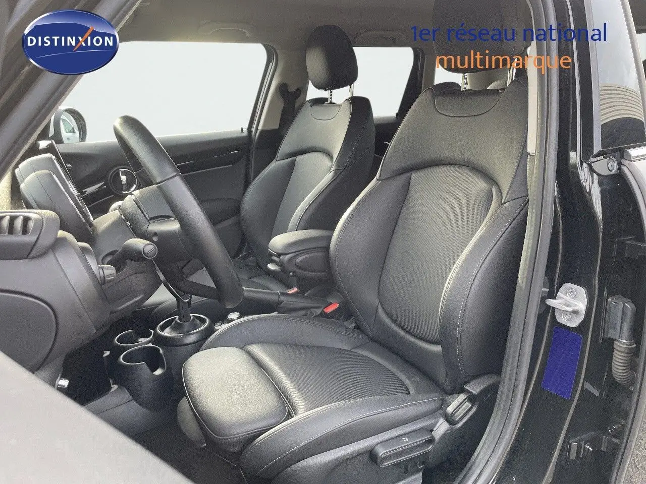 Intérieur de la MINI 1.5 136CH noir, vue côté conducteur montrant les sièges en cuir noir et la console centrale.