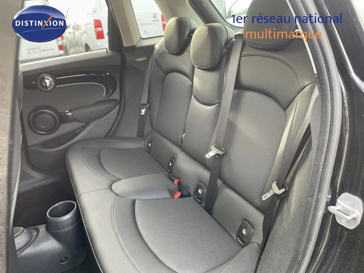 Vue intérieure côté droit sur la banquette arrière en cuir noir d'une MINI 2023 noir Midnight Metal avec ceintures de sécurité visibles.