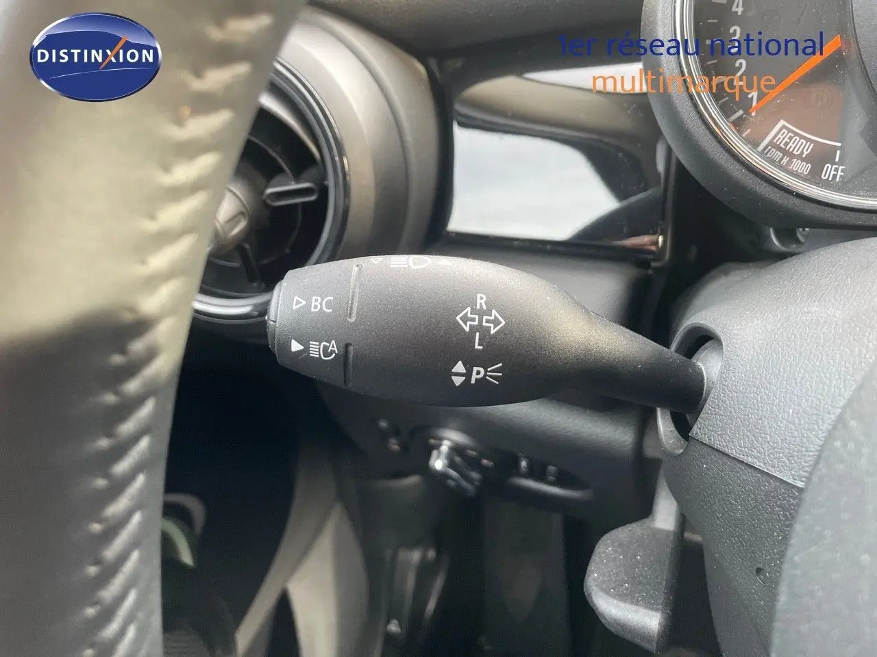 Gros plan sur la manette de clignotant à gauche du volant dans l'habitacle d'une MINI noire 2023.