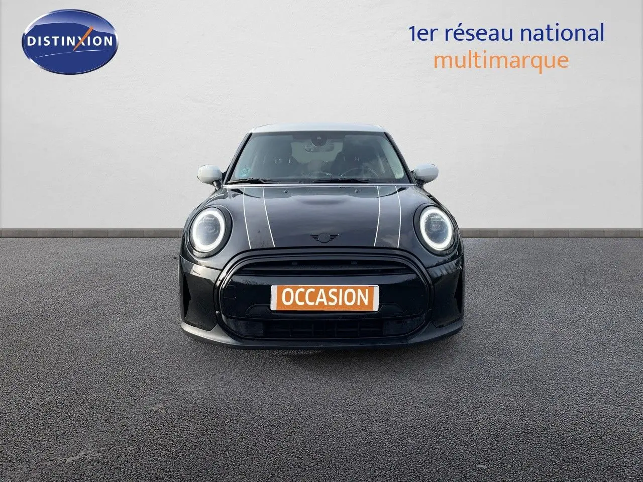 Vue frontale d'une MINI 1.5 136CH noire Midnight Metal avec toit blanc et bandes blanches sur le capot.