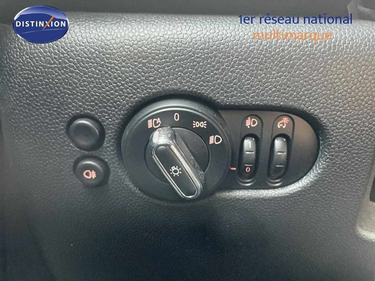 Gros plan sur les commandes d'éclairage et réglages du tableau de bord d'une MINI noire Midnight Metal 2023.