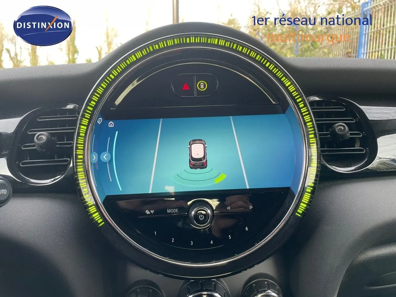 Écran central rond affichant l'aide au stationnement d'une MINI noire, vue intérieure du tableau de bord.