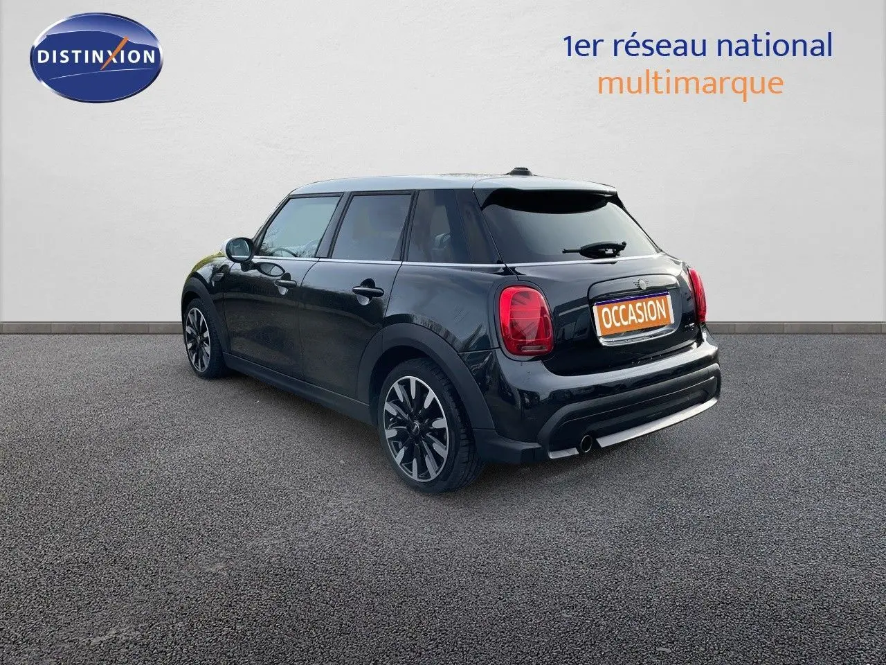 Vue 3/4 arrière droite d'une MINI noire Midnight Metal 5 portes avec jantes bi-ton et feux LED distinctifs.