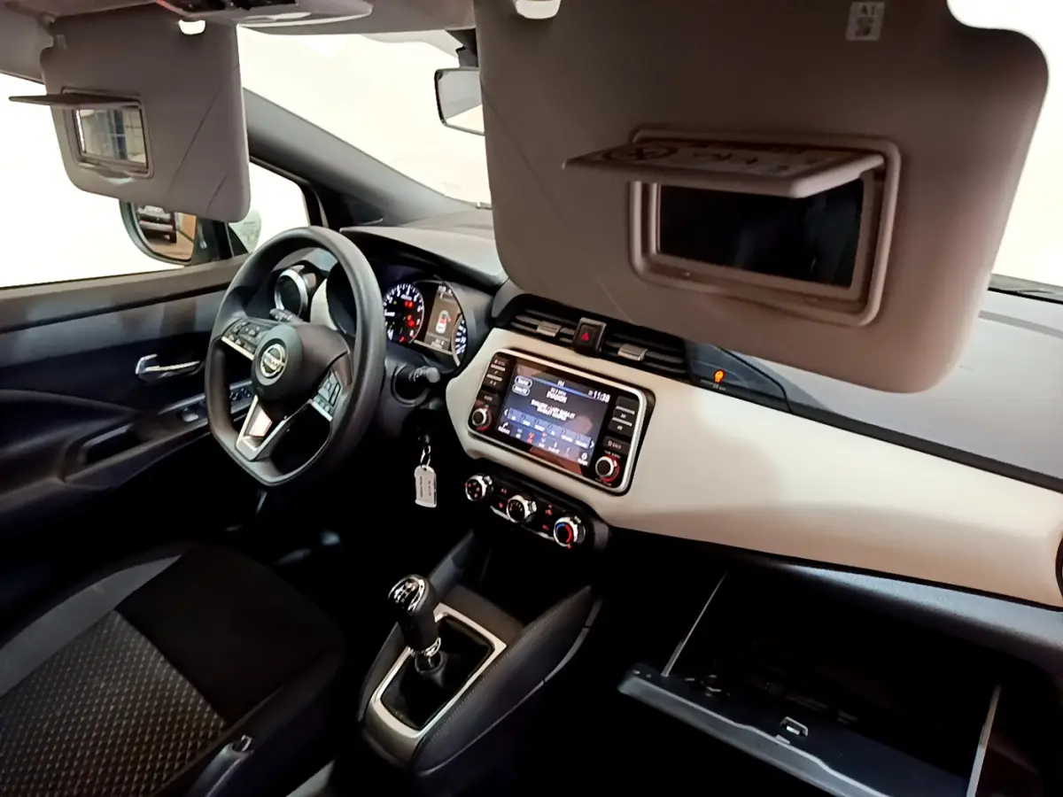 Intérieur de la Nissan Micra blanc, vue côté conducteur, tableau de bord avec écran tactile et volant multifonctions.