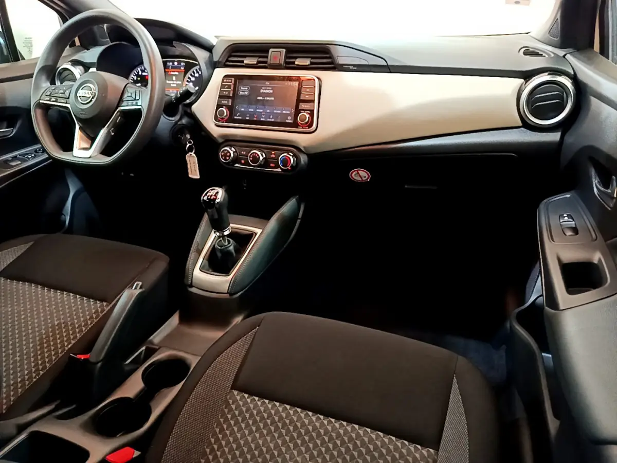 Vue intérieure avant droite de la Nissan Micra IG-T 92 Acenta 2022 avec tableau de bord clair et volant multifonctions noir.
