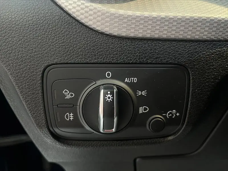 Commande des phares en gros plan sur tableau de bord noir de l'Audi Q2 30 TFSI S-Line 2021.